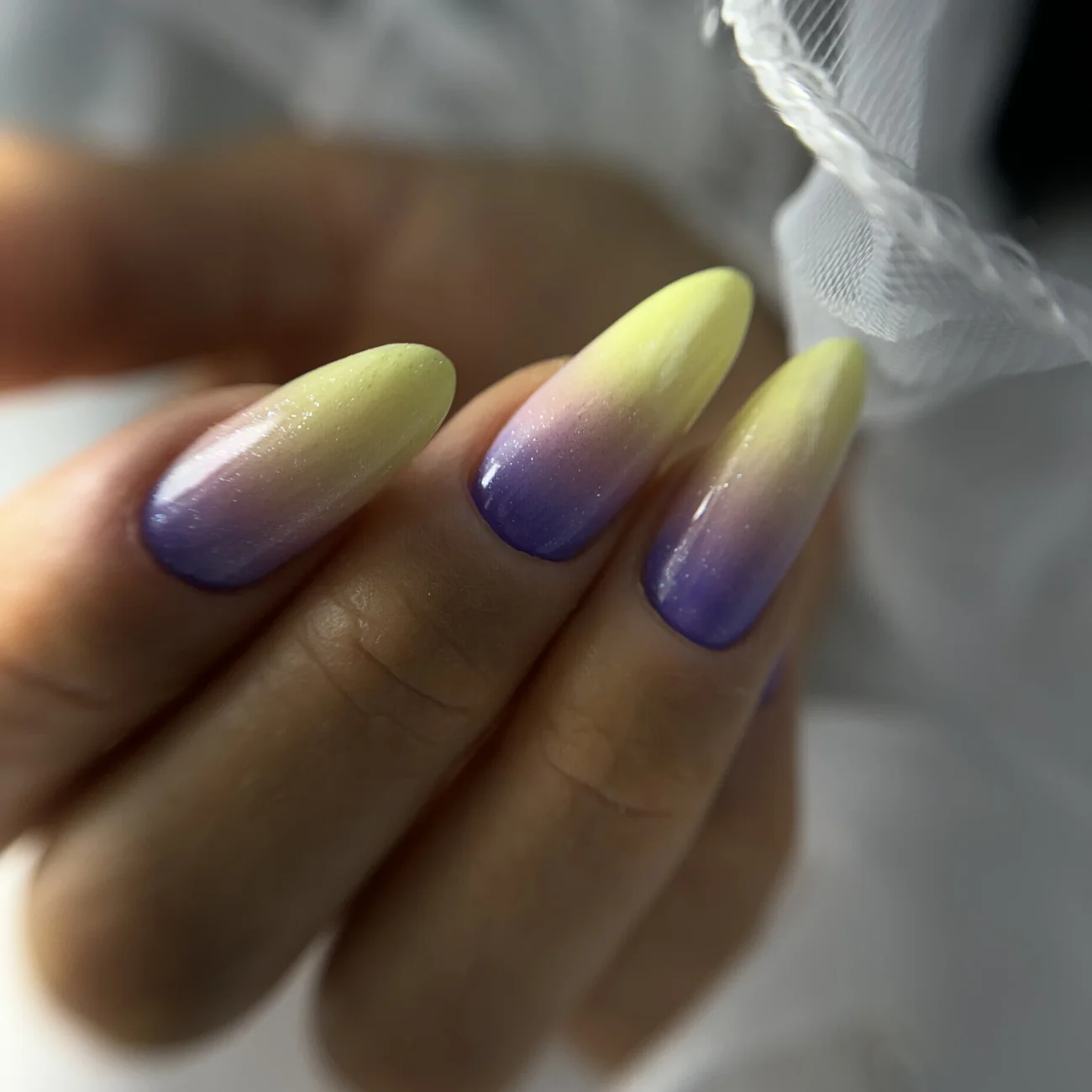 Coffin-shaped nails with a gradient effect from yellow to purple.