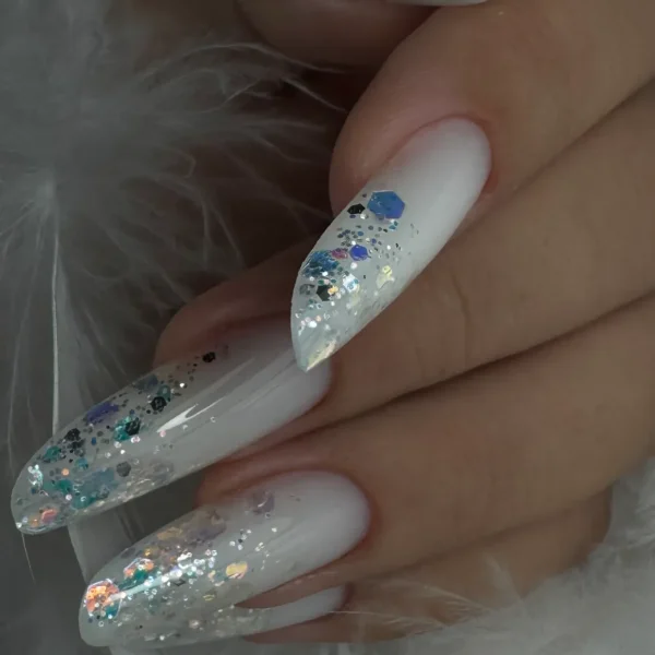 Stiletto nails with a white base and glitter accents.