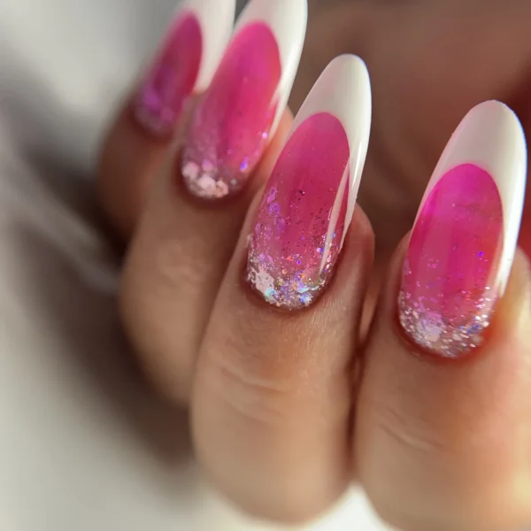 Almond-shaped pink ombre nails with glitter accents.