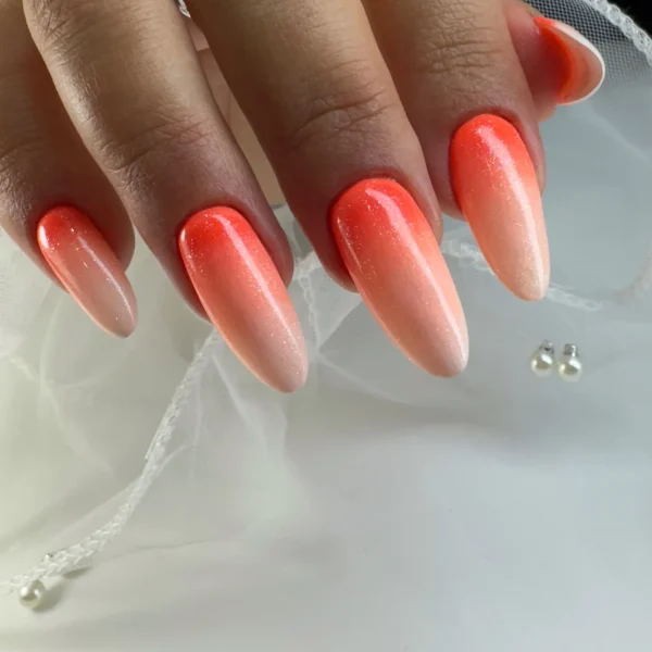 Almond-shaped nails with a neon orange gradient and a glossy finish.