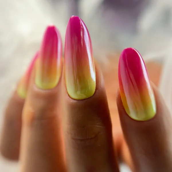 Almond-shaped ombre nails with pink, yellow, and green tones.