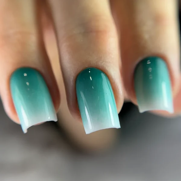 Coffin-shaped teal ombre nails with a glossy finish.