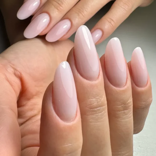 Almond-shaped nails in a soft pale pink with a glossy finish.