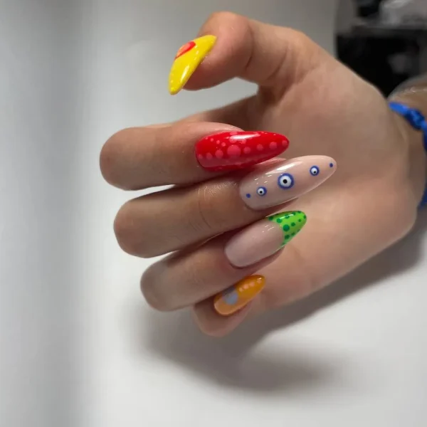 Coffin-shaped multicolor nails featuring playful artistic designs.